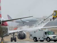 An American Airlines aircraft undergoes deicing procedures on Monday, Jan. 30, 2023, at...