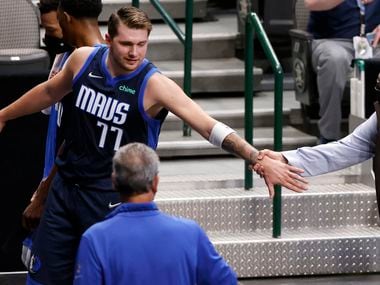 Dallas Mavericks guard Luka Doncic (77) reaches back for General Manager Donnie Nelson as they leave the floor with a lead at the half over the Cleveland Cavaliers at the American Airlines Center in Dallas, Friday, May 7, 2021. (Tom Fox/The Dallas Morning News)
