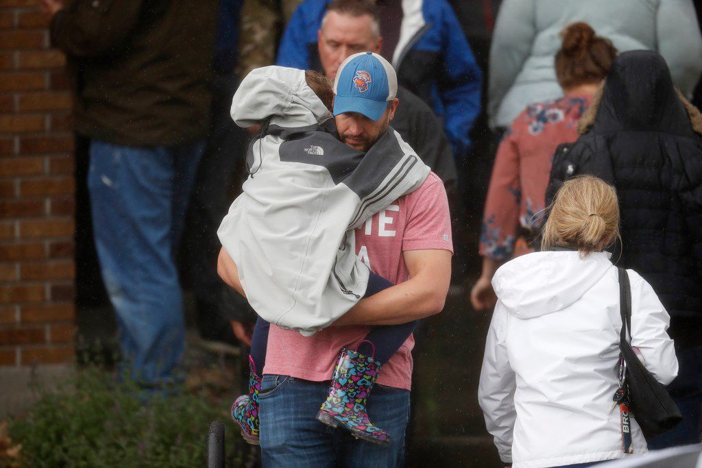 A man carried a child out of a recreation center set up for students to get reunited with...