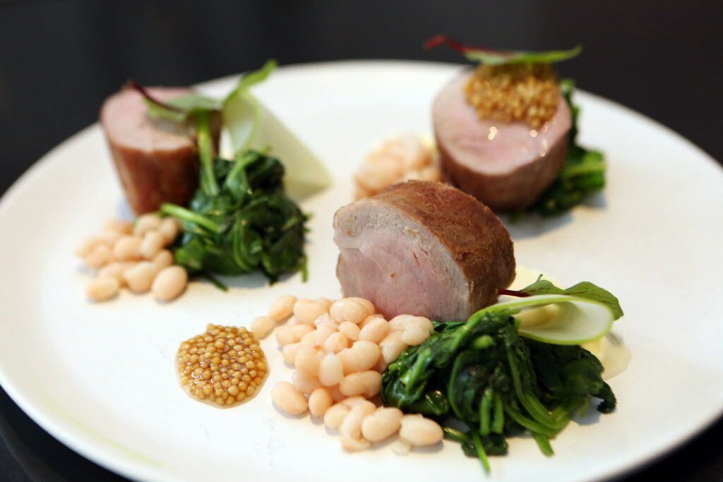 The pork loin at Cafe Momentum includes cider beans, mustard seed, and apple, shown in...