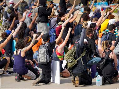 Demonstrators take a knee at Dallas Police Headquarters as protests continue after the death...