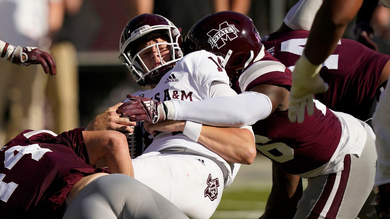 Texas A&M quarterback Max Johnson is tackled by Mississippi State defenders during the first...