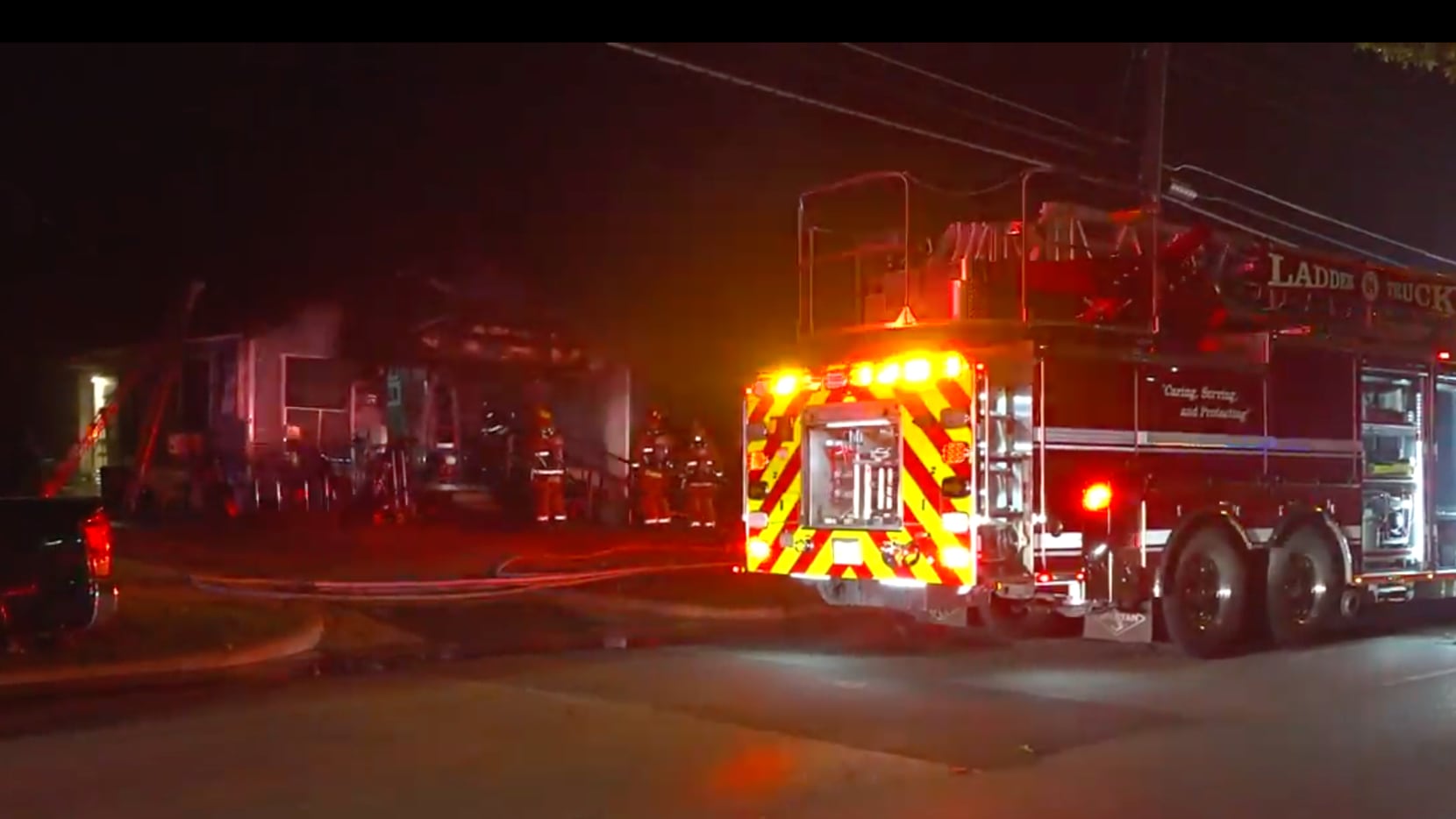 Bomberos trabajando para extinguir un incendio en una casa en South Dallas.