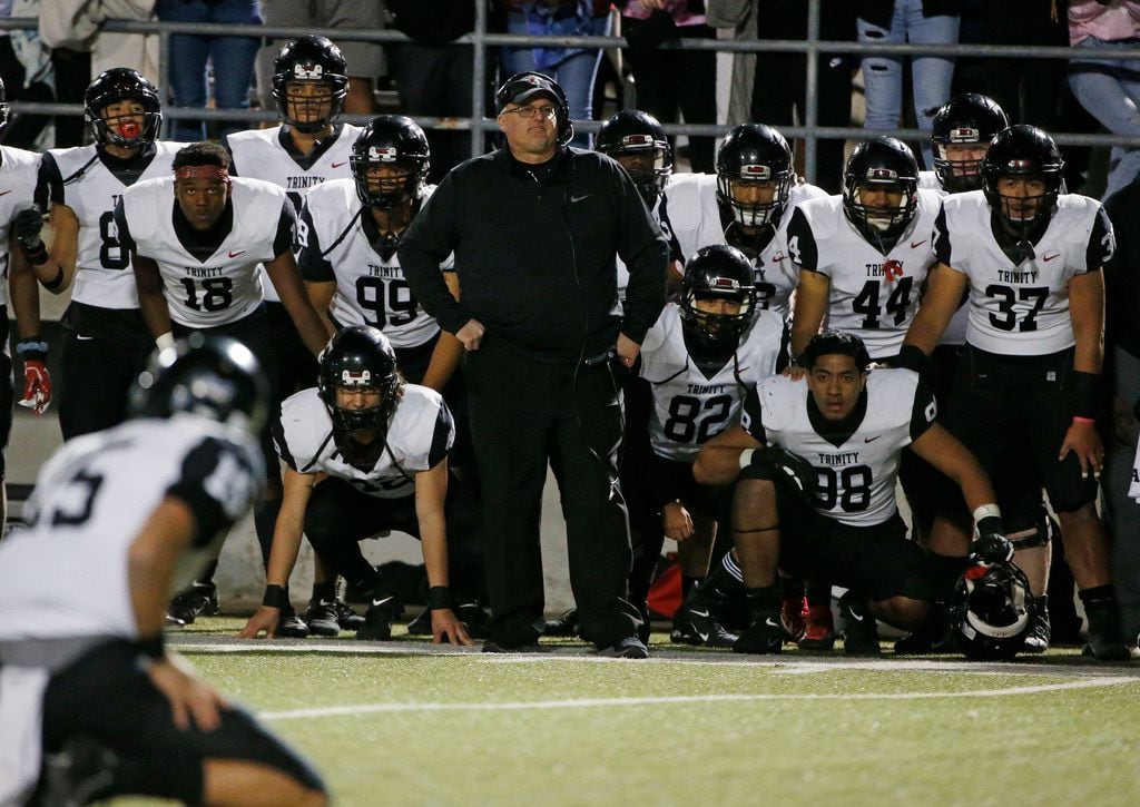 Euless Trinity head coach Chris Jensen and player watch as they lined up for a field goal...