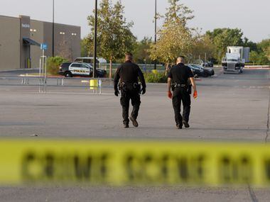 San Antonio police officers investigate the scene where eight people were found dead in a...