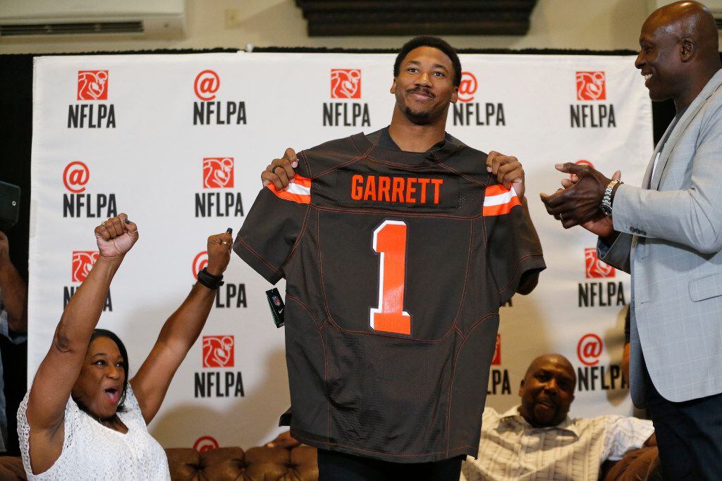 Myles Garrett of Texas A&M and Arlington Martin holds up his Cleveland Browns jersey as his...