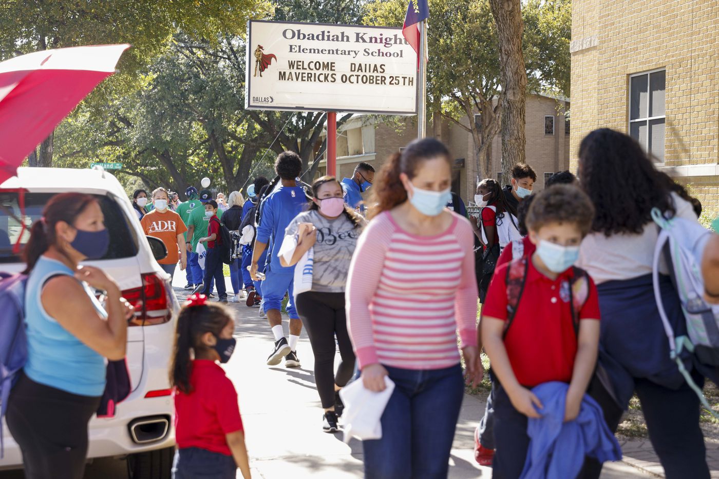 Family members walk students after the end of classes at Obadiah Knight Elementary School on...