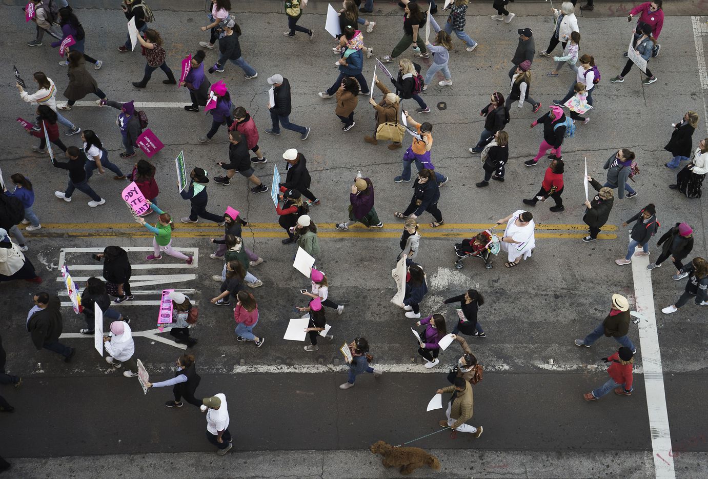 Participants in the 2020 Dallas Women's March walk along Harwood Street on their way to a rally at Dallas City Hall on Sunday, Jan. 19, 2020.