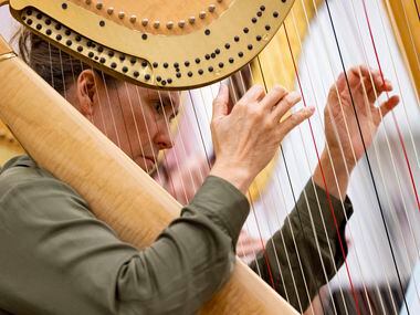 Jaymee Haefner, one of six harpists, performs during the orchestral rehearsal for Dallas...