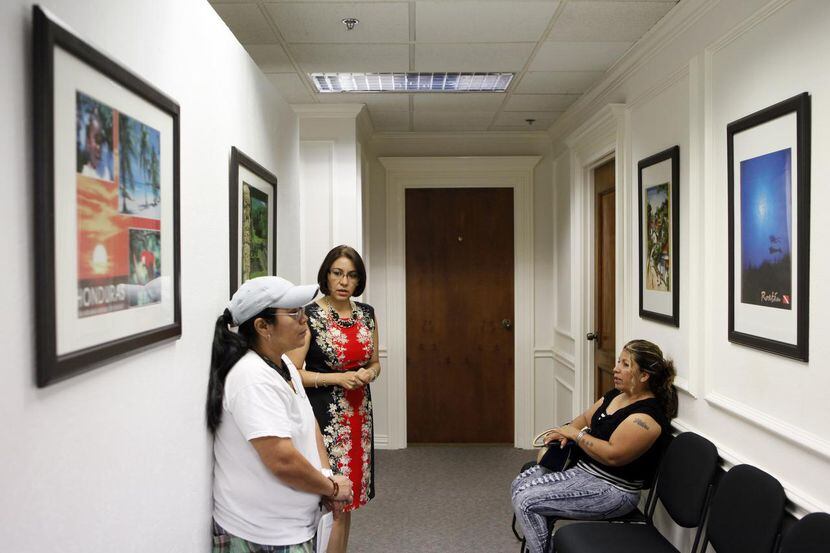 La cónsul general Gloria Alvarado (centro) conversa con dos connacionales en el Consulado de...