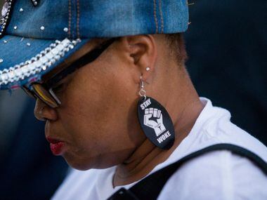 Dr. Pamela Grayson bows her head as she listens during a Mothers Against Police Brutality...