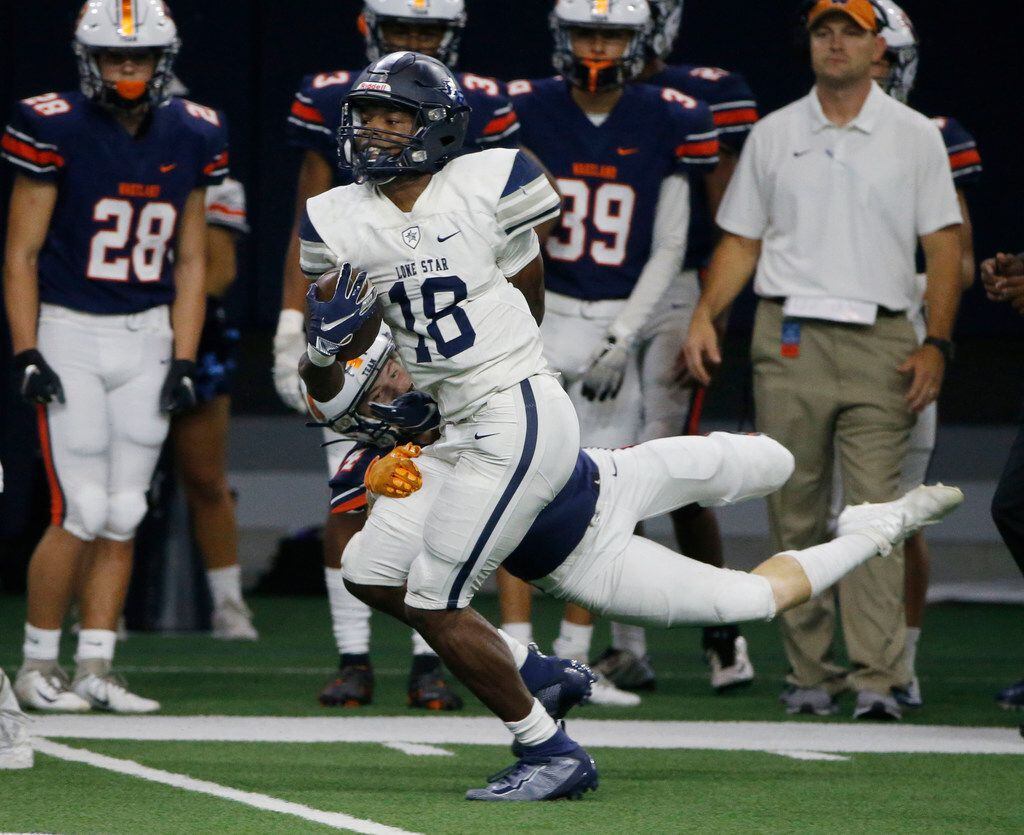 Frisco Lone Star's Marvin Mims (18) gets out of a tackle by Frisco Wakeland's  Josh Starnes...