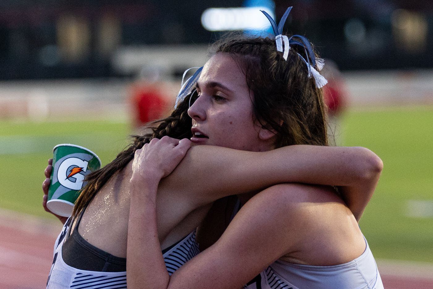 Natalie Cook, right, hugs Flower Mound teammate Nicole Humphries after the girls’ 1600-meter...