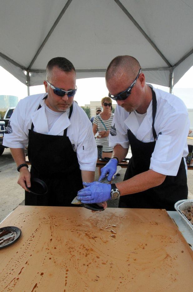 Jeff McNair and Jason Johnson of Kaufman County Police Department pile a plate of brisket at...