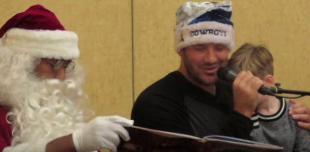 Tony Romo, with son Hawkins in  his lap, reads Twas the Night Before Christmas to children...