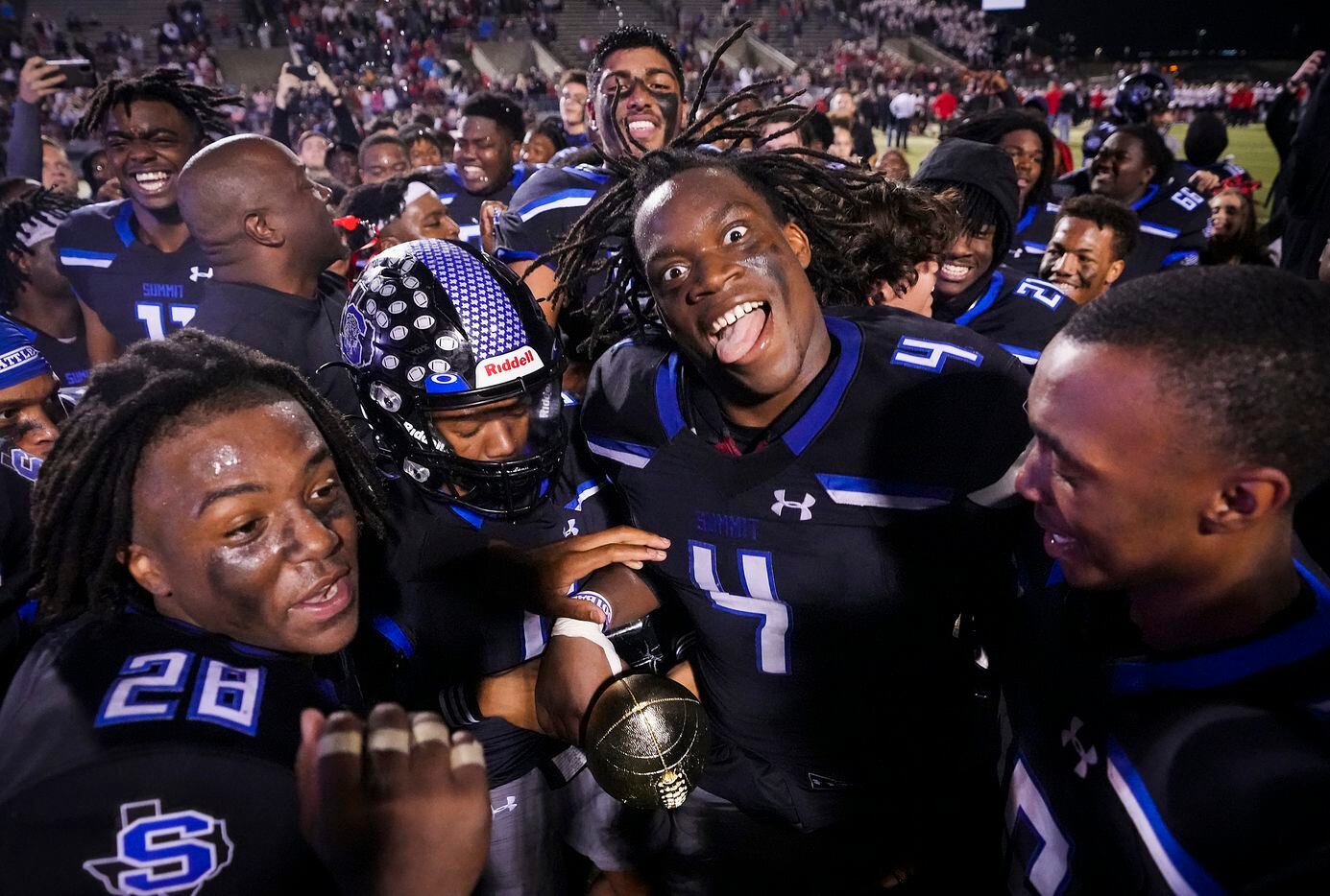 Mansfield Summit defensive lineman Joseph Adedire (4) celebrates with the game trophy after a victory over Colleyville Heritage in the Class 5A Division I Region I final on Friday, Dec. 3, 2021, in North Richland Hills, Texas. (Smiley N. Pool/The Dallas Morning News)