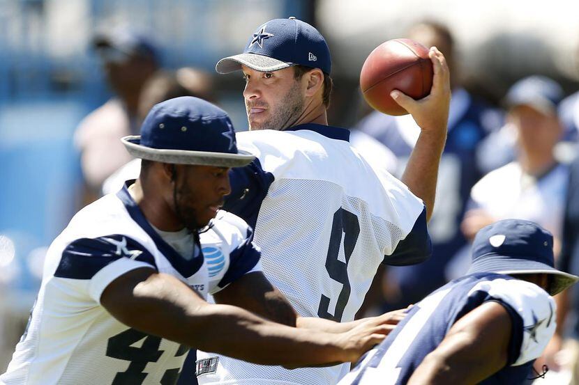 El mariscal de los Cowboys de Dallas Tony Romo practica lanzar el balón en el entrenamiento...
