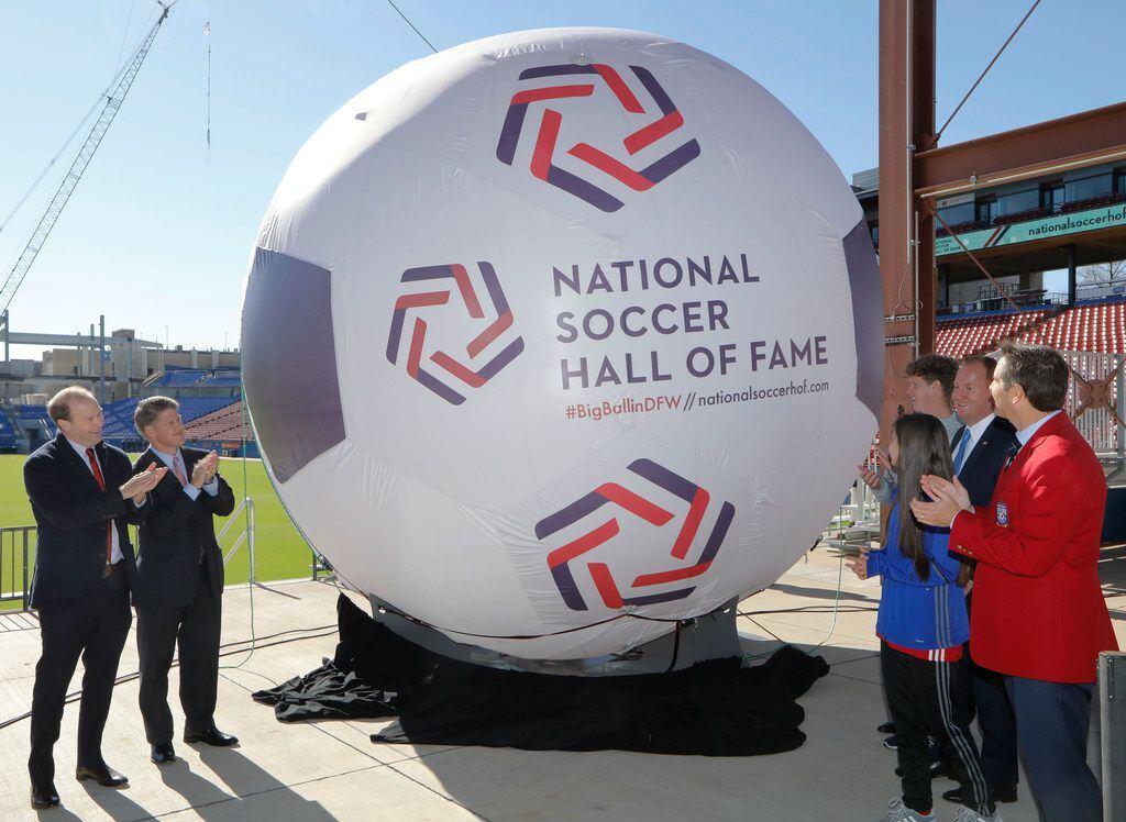 From left: FC Dallas president Dan Hunt, FC Dallas chairman Clark Hunt, Frisco Mayor Jeff Cheney (blue tie), and John Harkes (red coat), a member of the 2005 National Soccer Hall of Fame class were among those unveiling the new logo for the National Soccer Hall of Fame on Tuesday.  