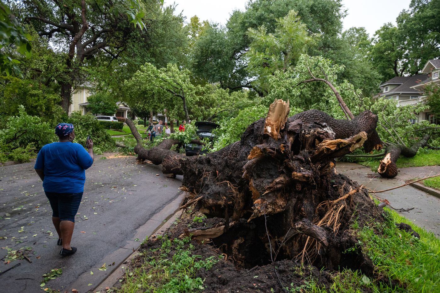 LaTasha Kelly, 39, left, speaks to her family on her phone as she stands next to a fallen...