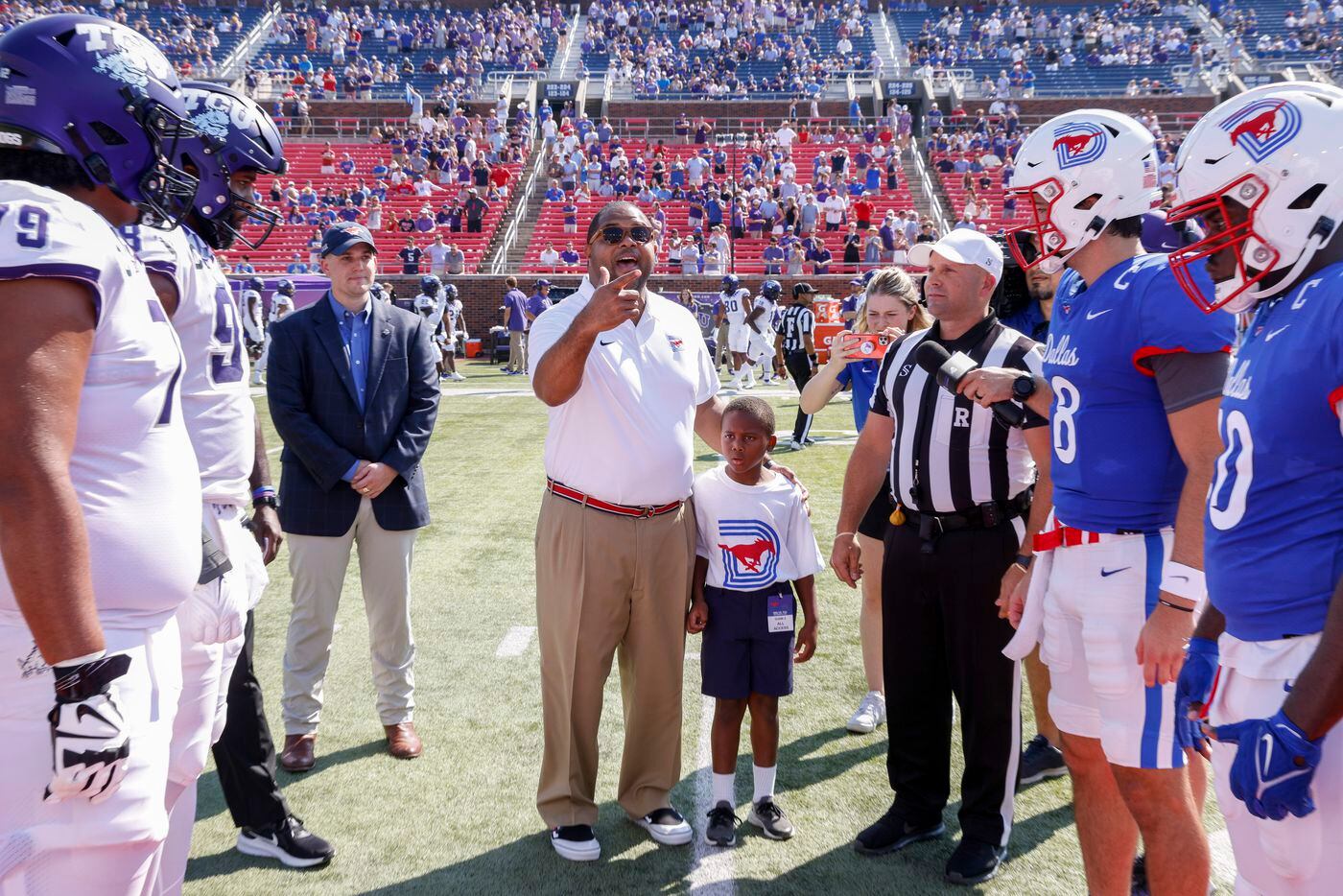 Dallas Mayor Eric Johnson conducts the coin toss with his son William Johnson, 8, before a...