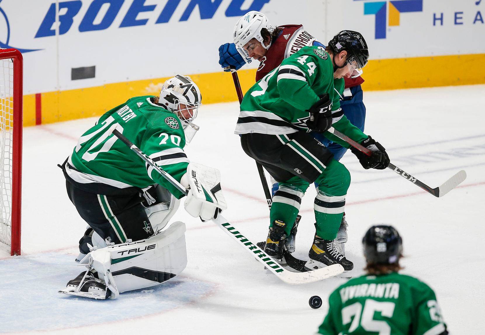 Dallas Stars goaltender Braden Holtby (70) plays the puck away as  defenseman Joel Hanley (44) battles Colorado Avalanche forward Alex Newhook (18) for space during the second period of an NHL hockey game in Dallas, Friday, November 26, 2021. (Brandon Wade/Special Contributor)