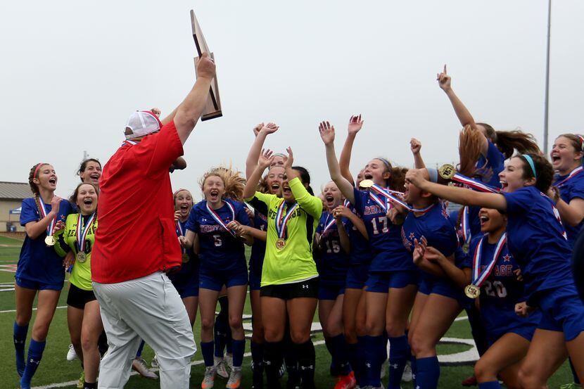 Midlothian Heritage head coach Gerald Slovacek cheers with his players as he holds up the...