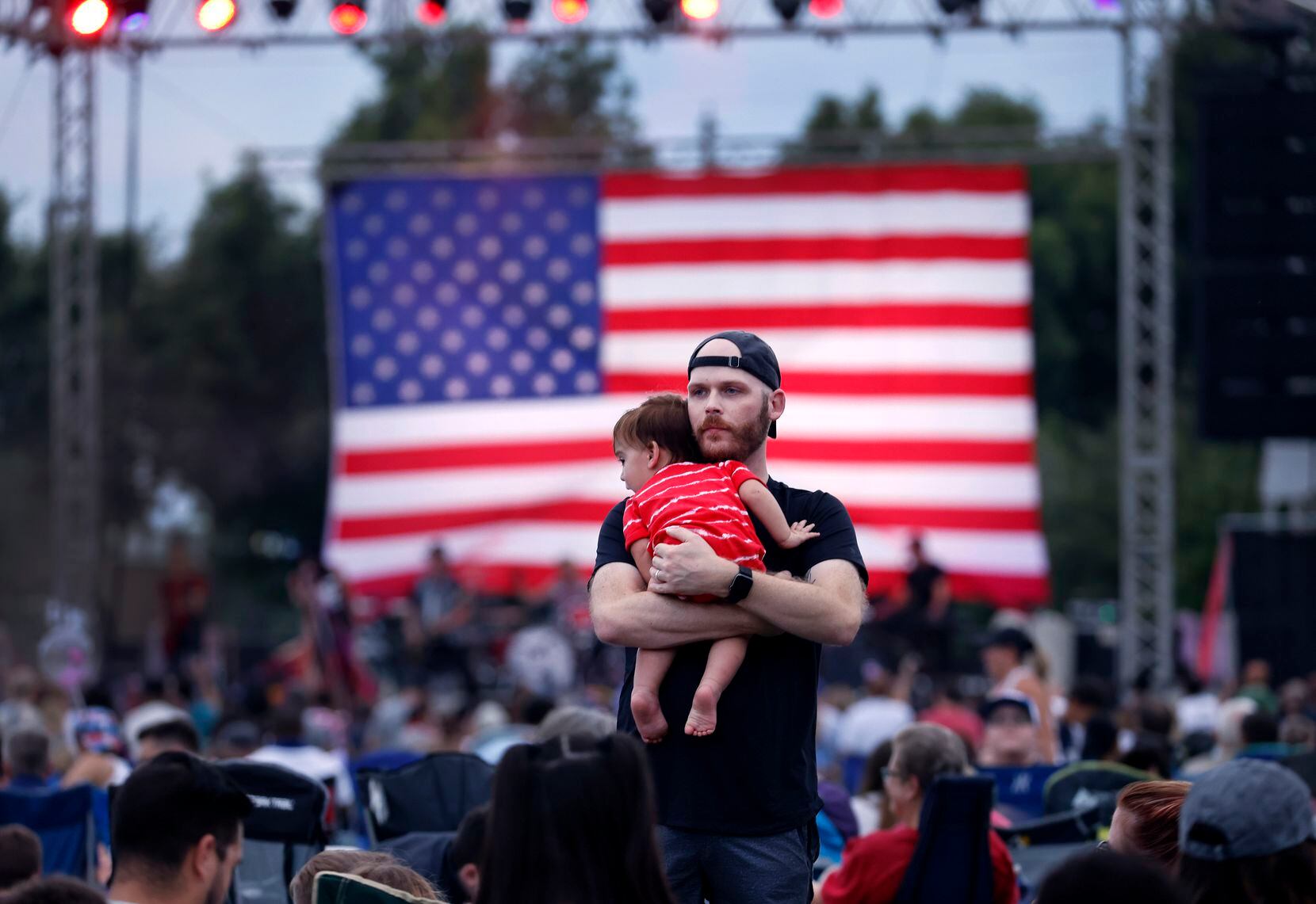Nick Schmidt of Farmers Branch rocked his son Ezra during the Addison Kaboom Town Fourth of...