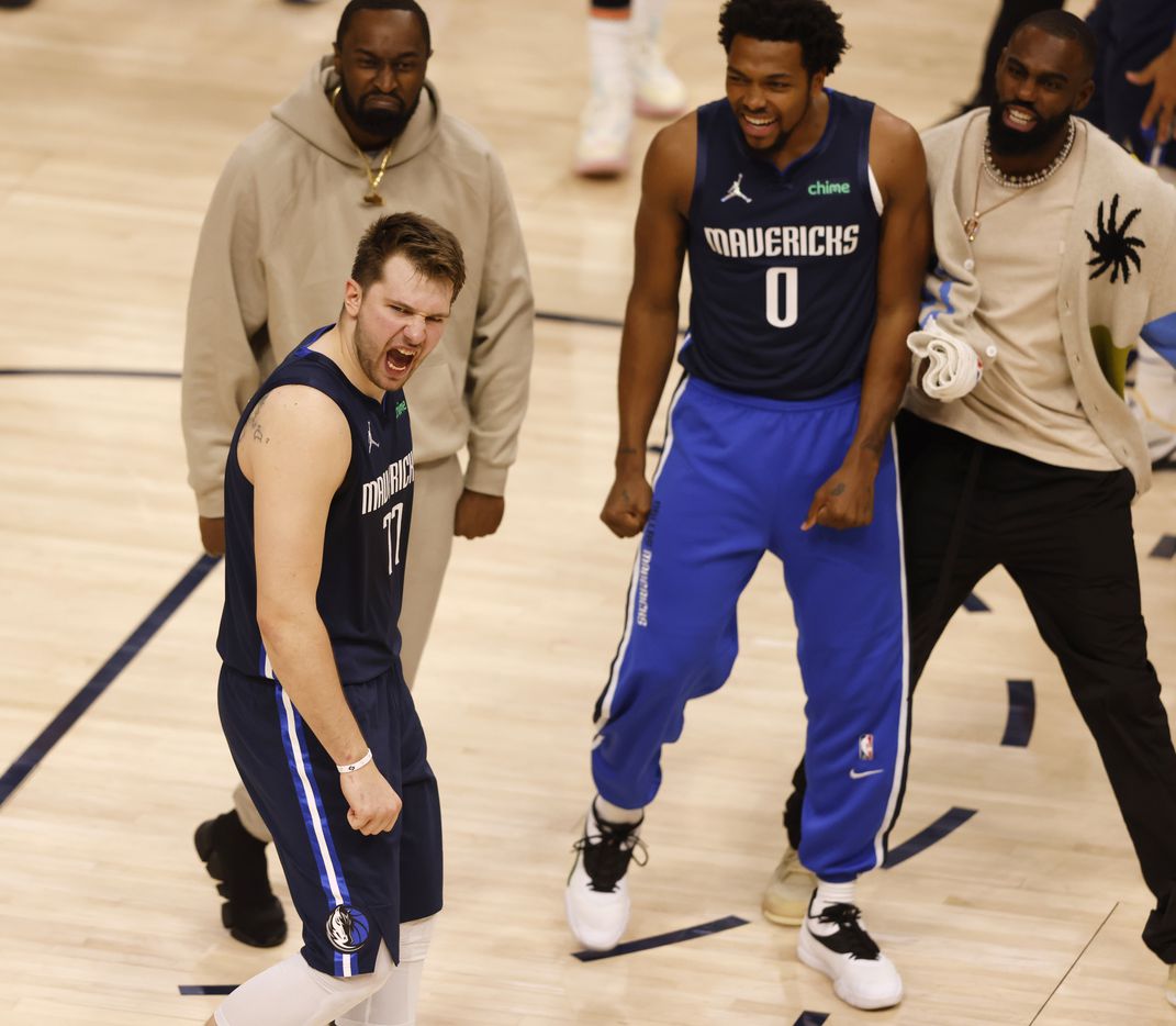 Dallas Mavericks guard Luka Doncic (77) celebrates as teammates come towards him after...
