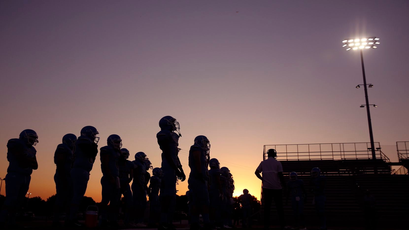 As the sun sets behind Loos Stadium, the Thomas Jefferson football team waits to take the...