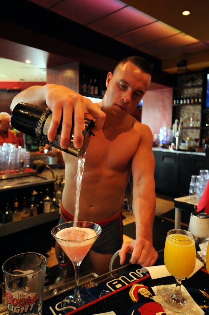 Shirtless bartender Brandon mixes, pours, and serves cocktails like it ain't no thing.