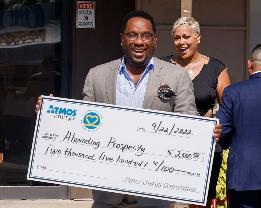 Kirk Myers-Hill, founder and CEO of Abounding Prosperity, smiles after receiving a donation...