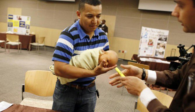 Miguel Cano aprende la manera correcta de sostener a un bebé durante el taller “Celebrando a...