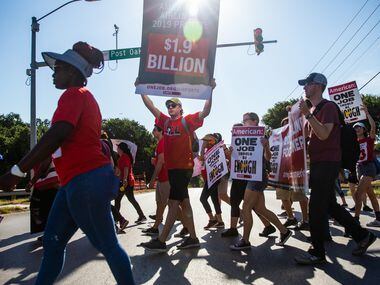 Jason Lopez (center) and other protesters march to the new corporate headquarters for...