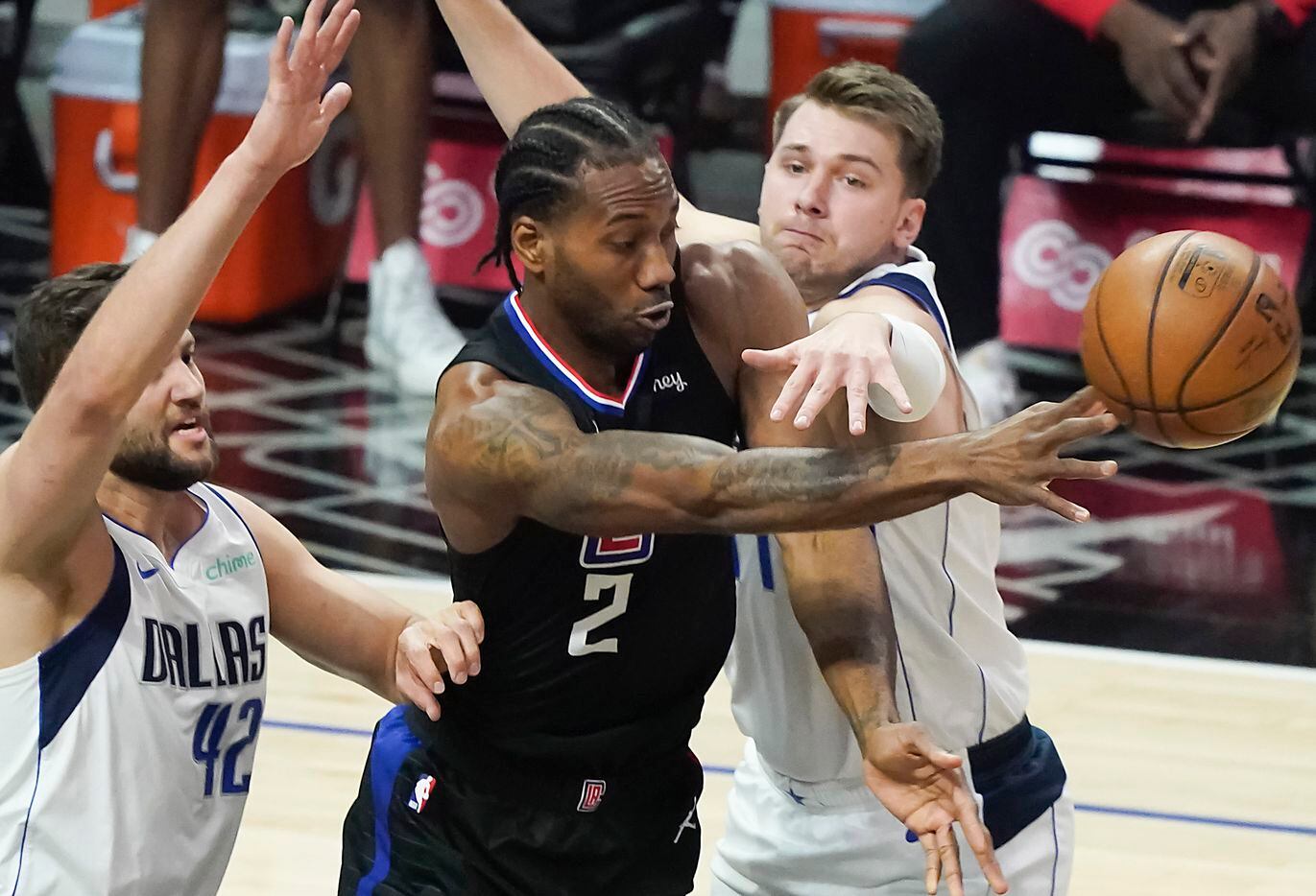 Dallas Mavericks guard Luka Doncic (77) and forward Maxi Kleber (42) defend against LA Clippers forward Kawhi Leonard (2) during the first half of an NBA playoff basketball game at Staples Center on Tuesday, May 25, 2021, in Los Angeles.