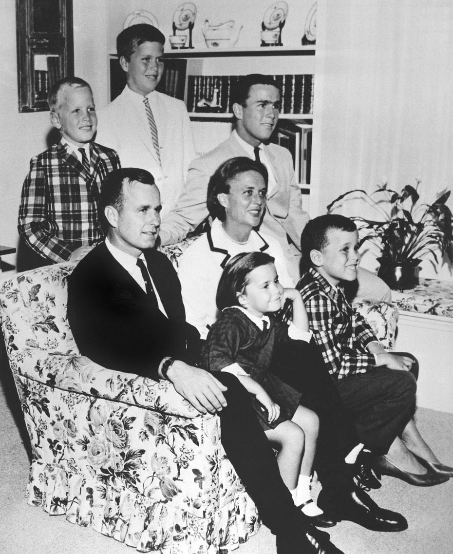 George H.W. Bush sits on couch with his wife Barbara and their children in 1964. George W....