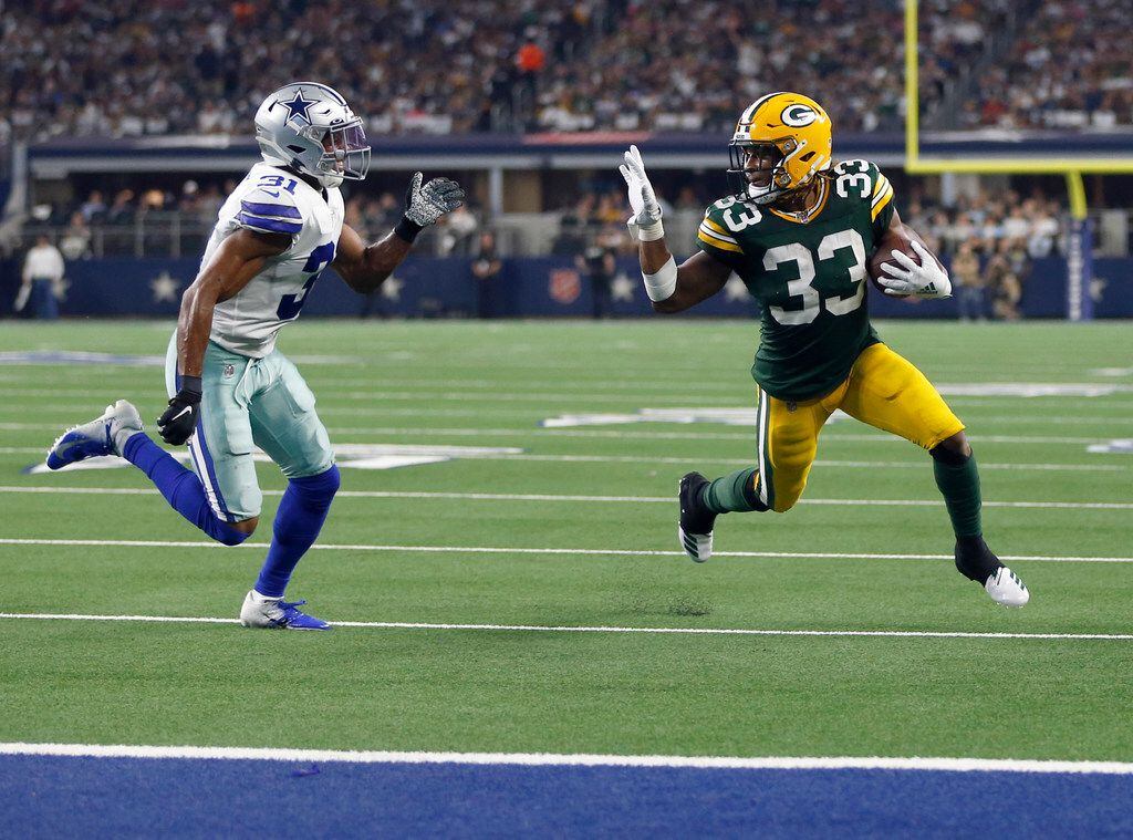 Green Bay Packers running back Aaron Jones (33) waves towards Dallas Cowboys cornerback...