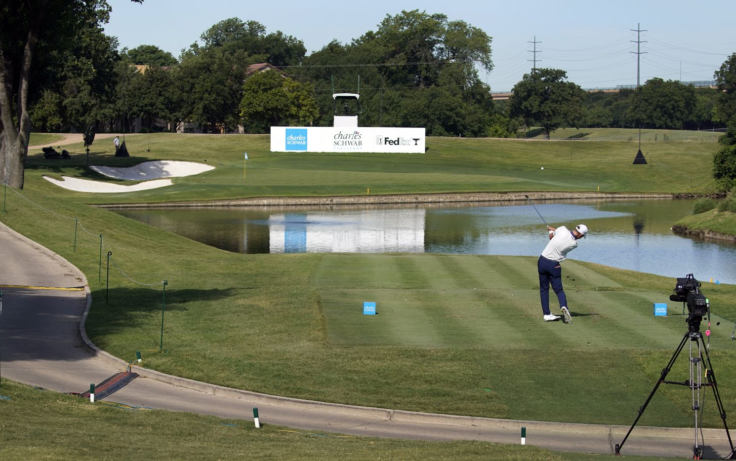 With no fans around the 13th tee box, a PGA Tour golfer follows through on his shot across...