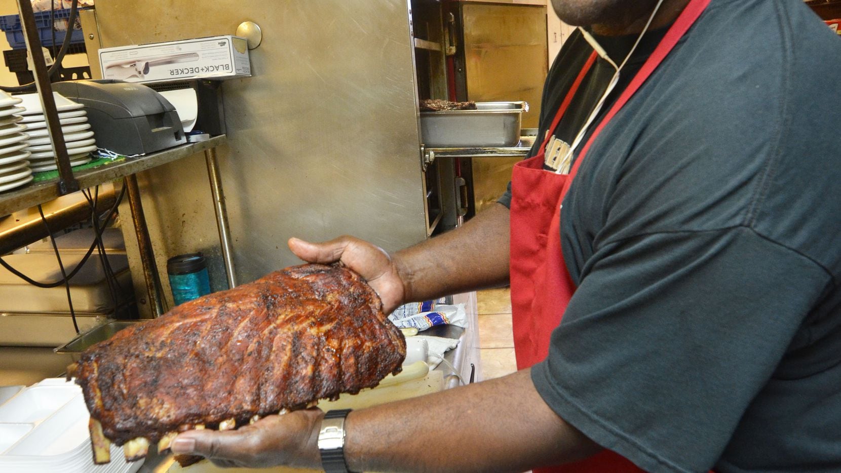 Leon s relative Buster Sidney shows a rack of ribs just extracted from the smoker.  Leon s...