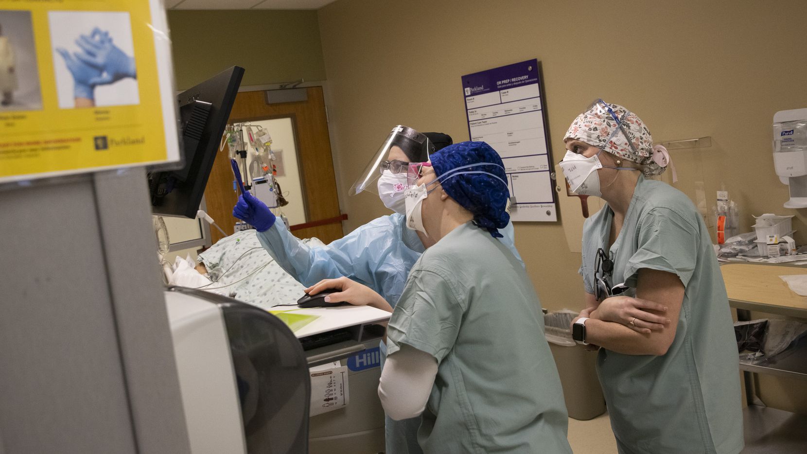 From left, nurses Kelsey O’Meara, Noelle Hackfeld, and Joanna Pless review an intubated...