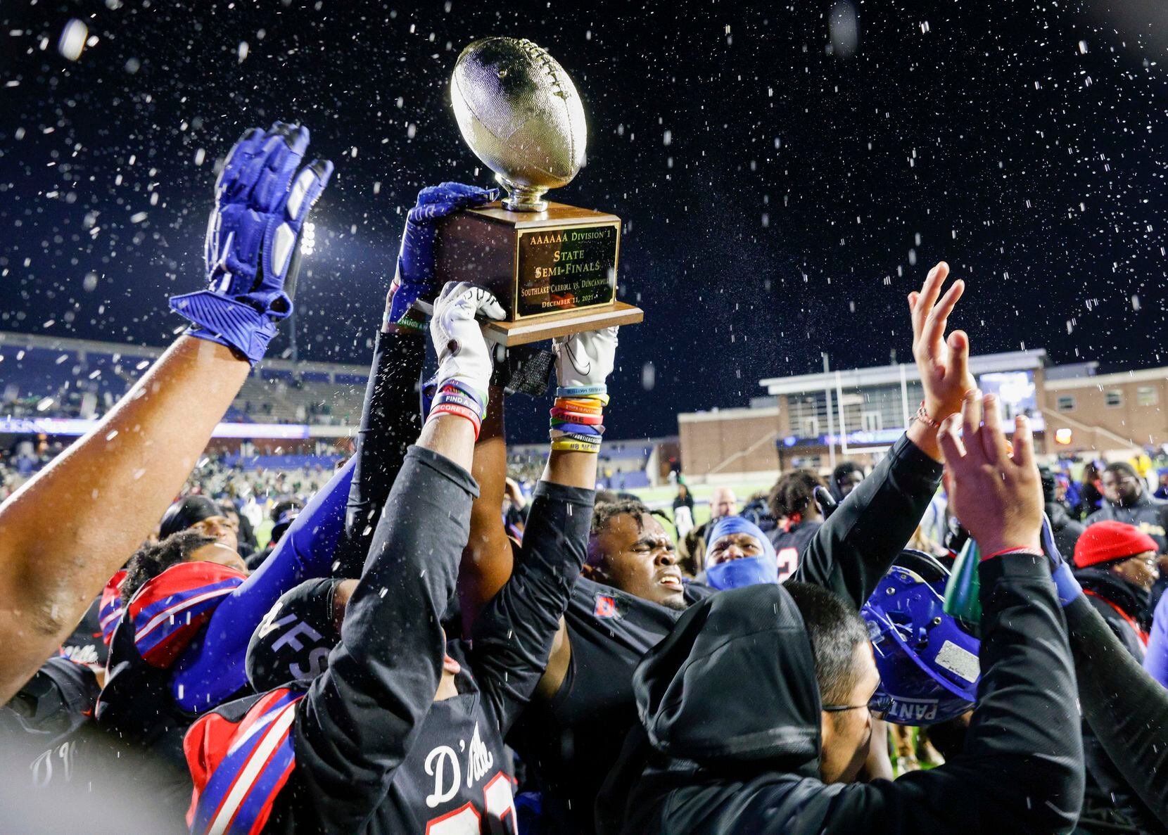 Duncanville players hoist the game trophy after defeating Southlake Carroll in their Class...