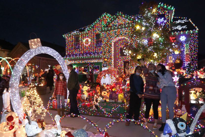 Foto del frente de la casa, con luces de muchos colores y figuras de venados y pingüinos de...