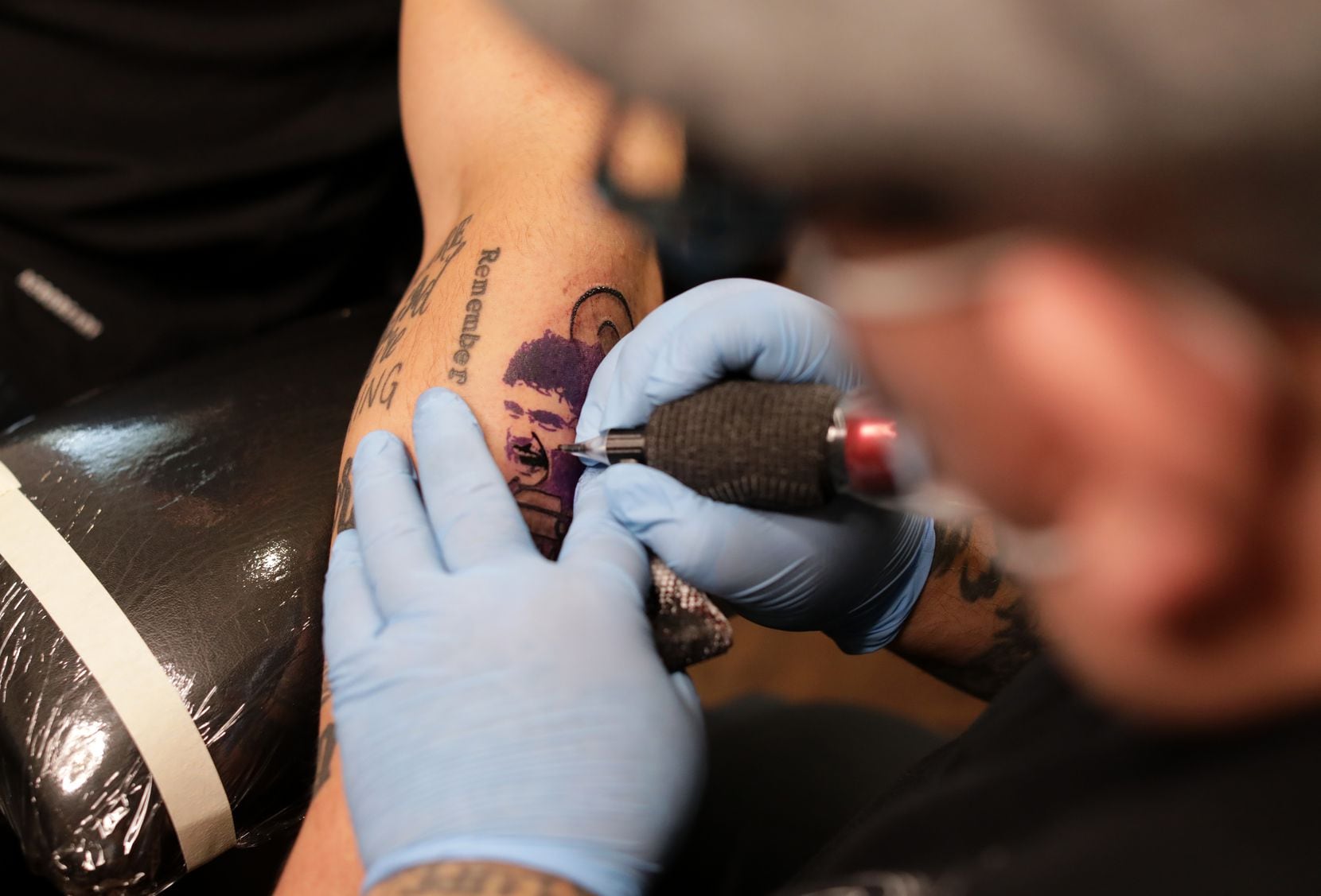 FC Dallas Social Media Coordinator, Eddie Koton, receives a tattoo from Mando Aguilar at La...