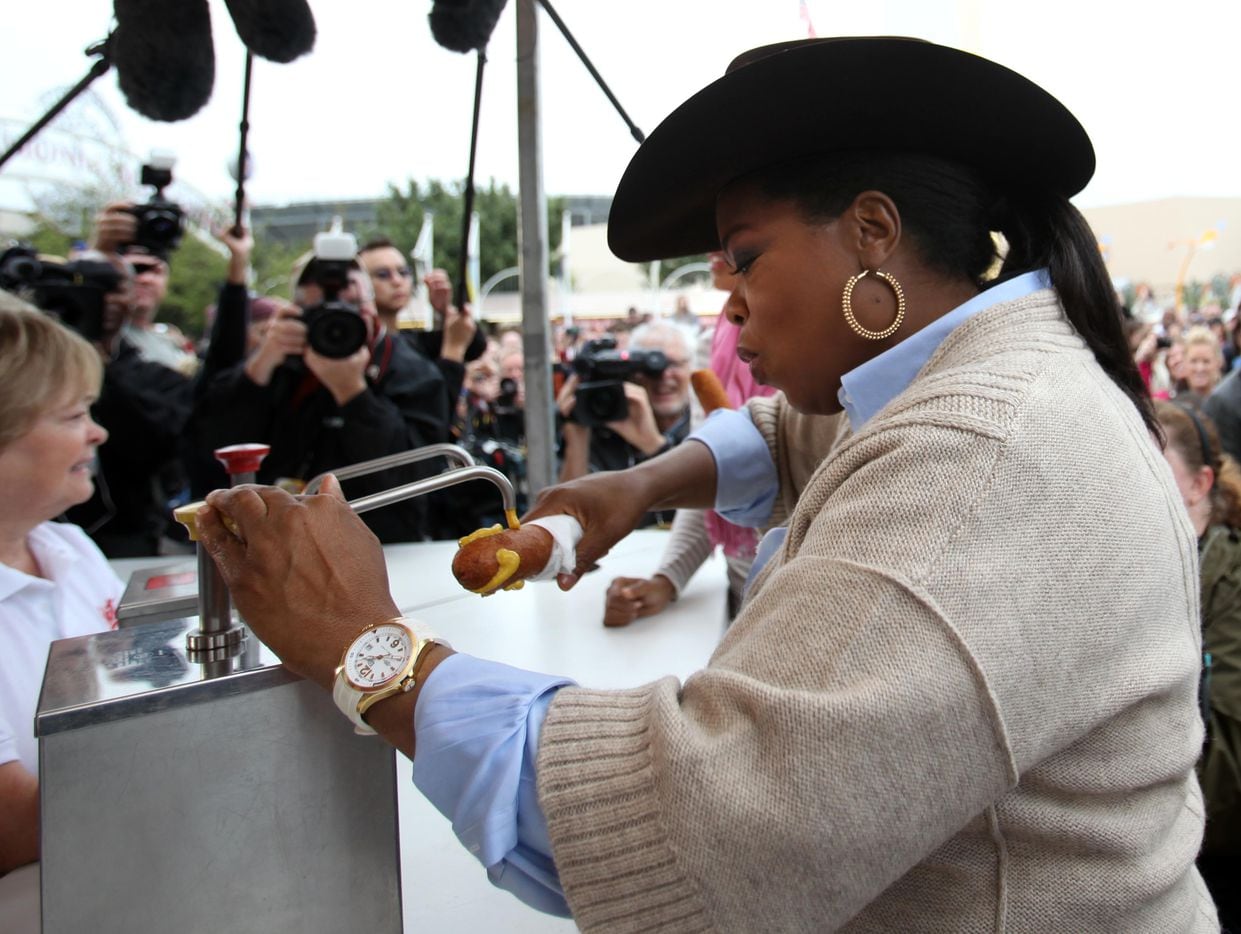  Oprah Winfrey applies mustard to her corny dog at the State Fair of Texas in Dallas on...
