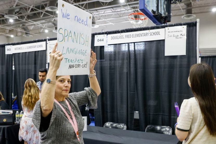 A Dallas ISD staffer carries a sign looking for Spanish teachers, including those who are...