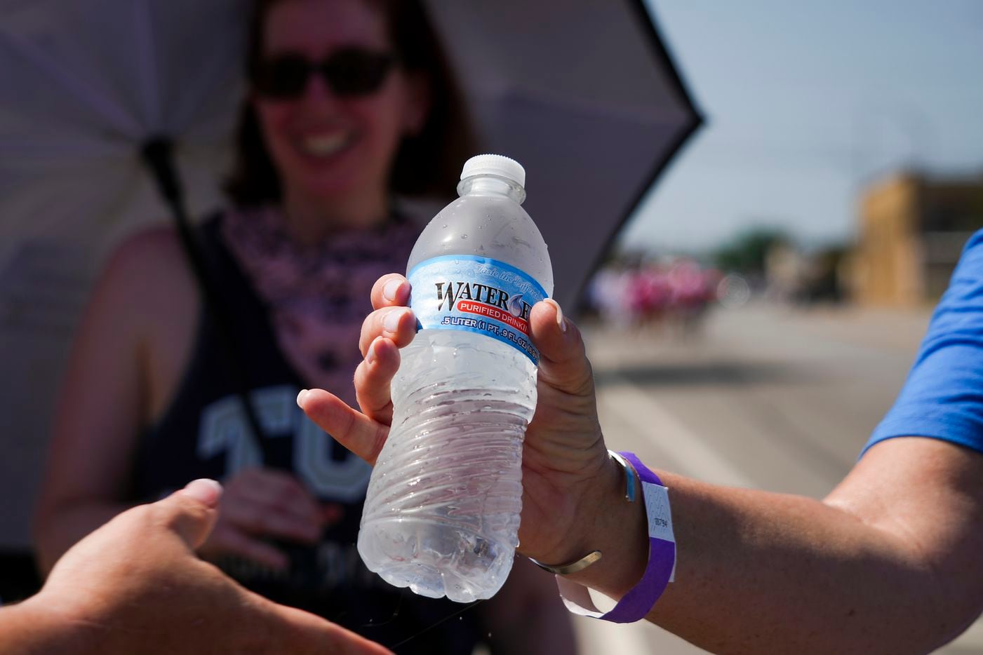 Volunteers hand out bottled water to walkers along Hemphill Street during the 2022 Opal's...