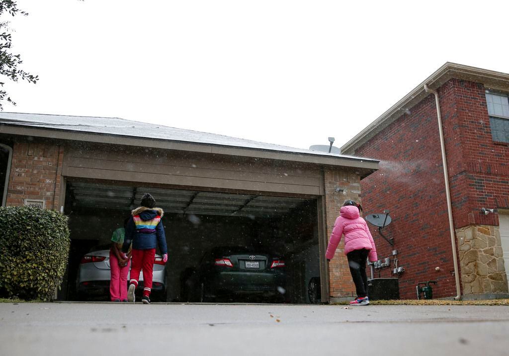 6-year-old Dasiya Small, left and her sister 7-year-old Damyri Small try to catch snow on...