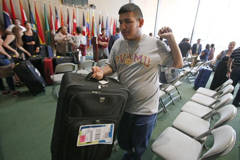 José Sandoval, de 18 años, lleva su maleta y una frazada durante la entrega de equipaje...