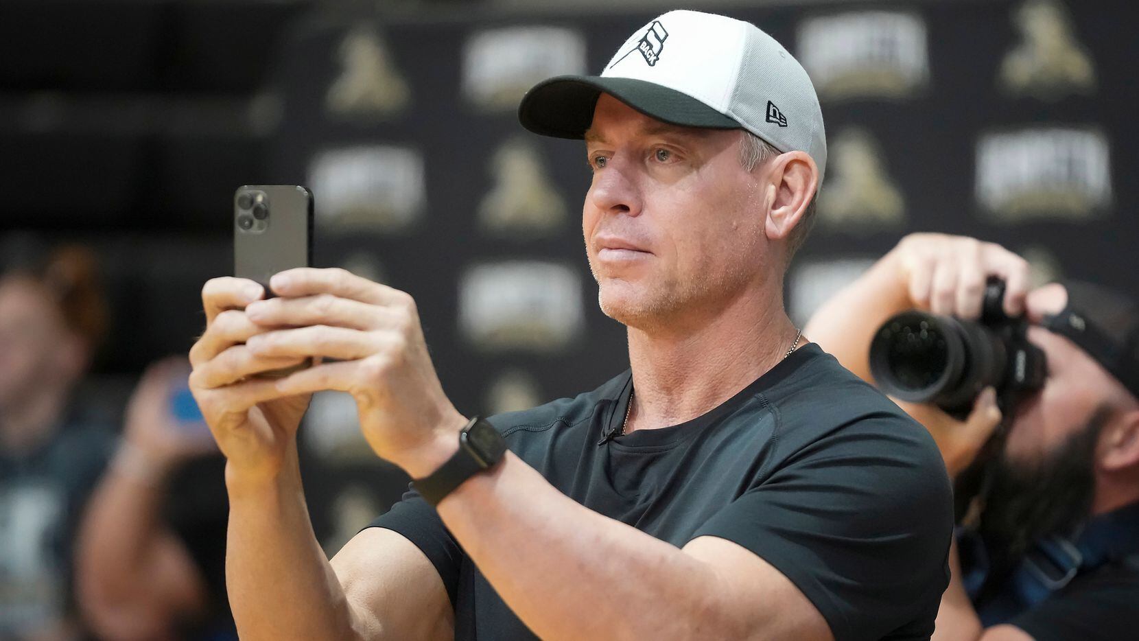 Troy Aikman records a performance by students during a pep rally at Henryetta High School on...