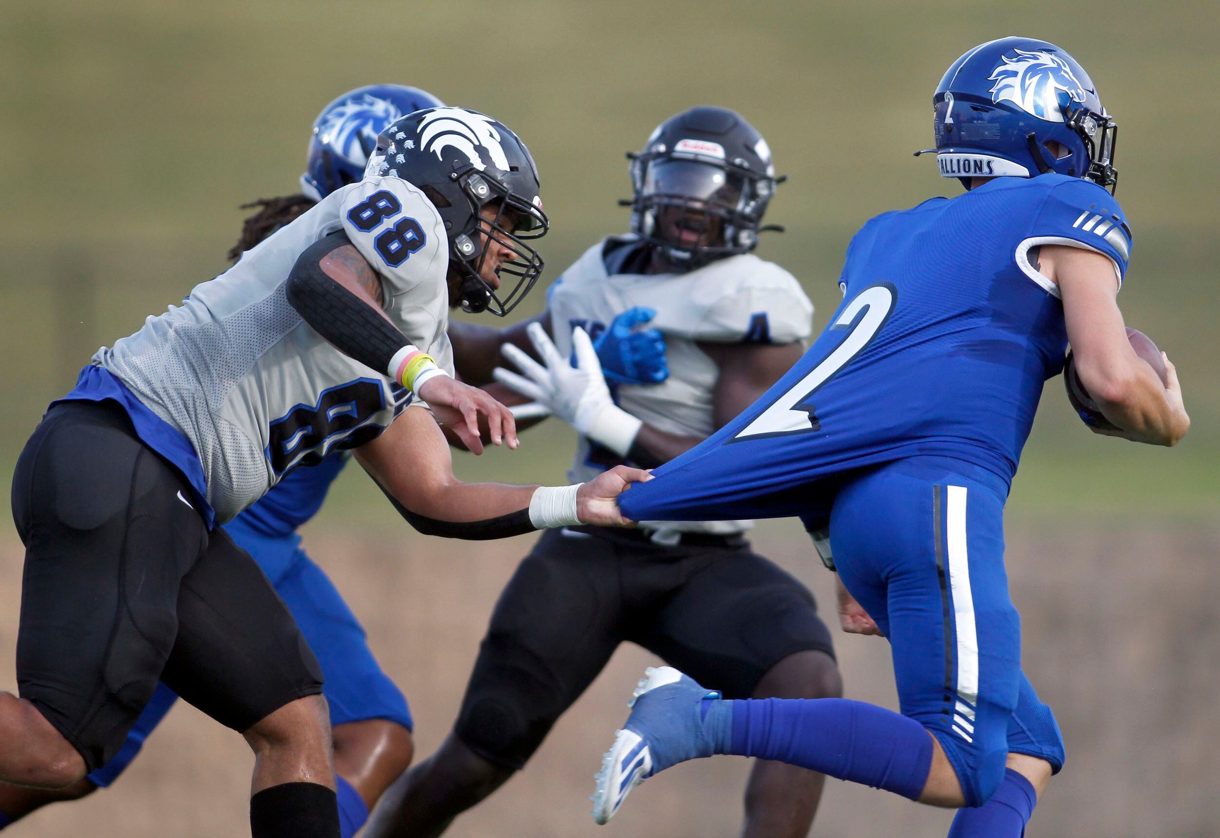 North Mesquite quarterback Luke Seder (2) is unable to elude the defense of Plano West...