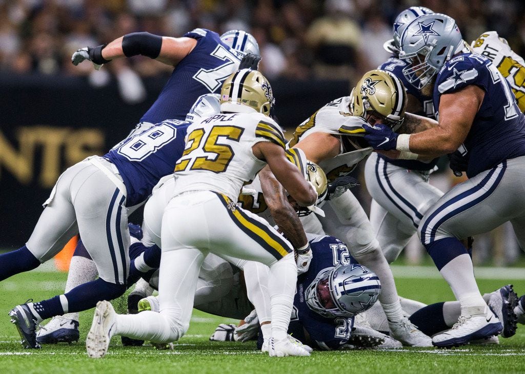 Dallas Cowboys running back Ezekiel Elliott (21) fumbles the ball while being tackled by New...